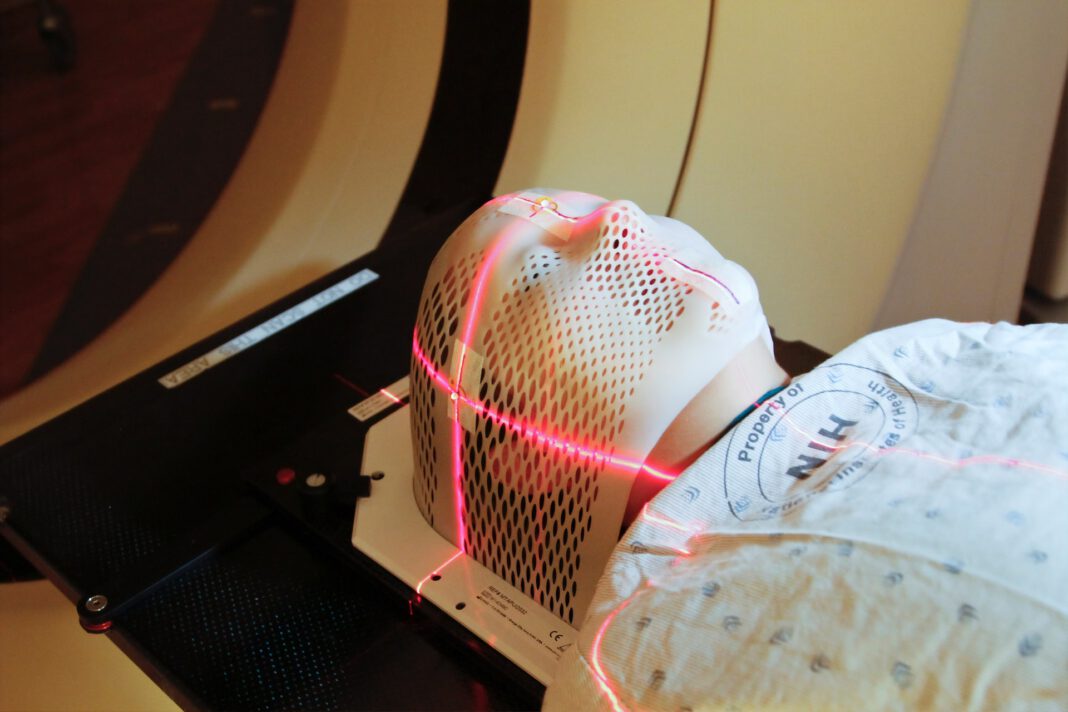 Lasers are used to position a patient model wearing a short face mask in a computed tomography (CT) scanner to obtain images of a tumor before radiation therapy. 2010